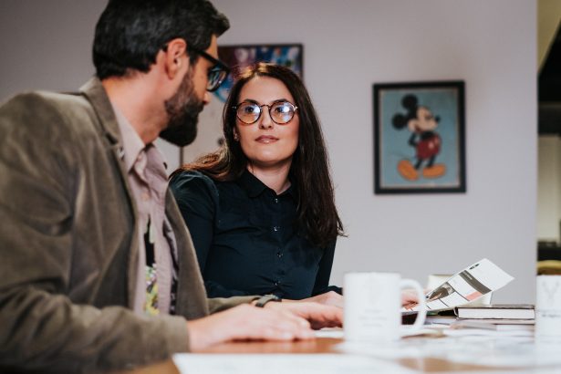 A businessman and woman, who William Smith of Double Iron Consulting can help, sit at a table